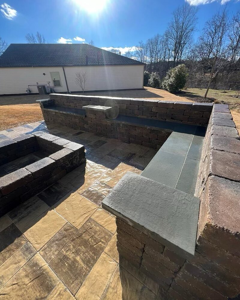 Side-by-side comparison of a stamped concrete patio and an interlocking paver patio
