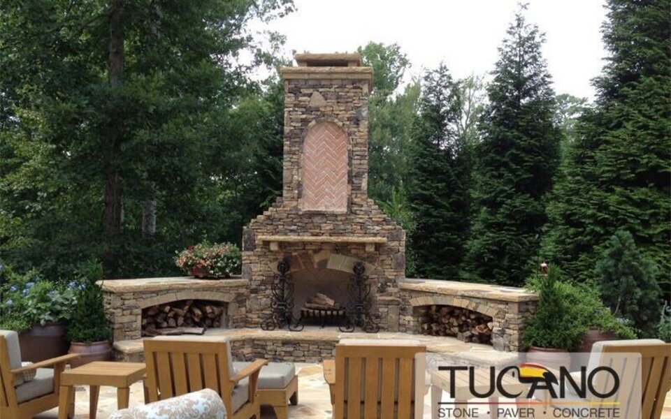 Custom outdoor stone fireplace with herringbone brick and seating area in Metro Atlanta