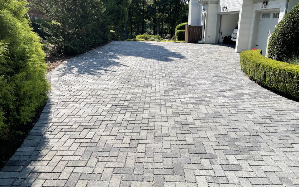 Permeable paver driveway with herringbone pattern and landscaped borders in Metro Atlanta