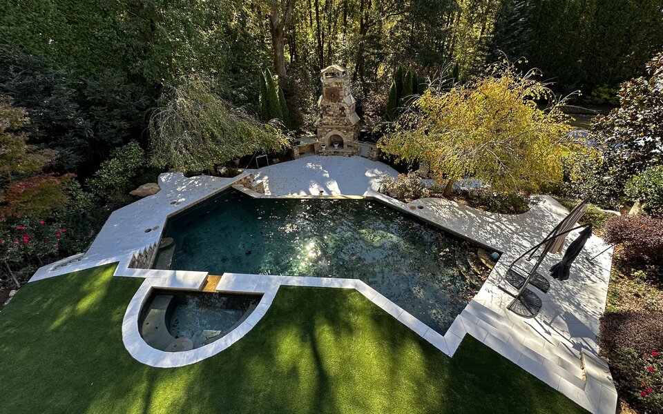Custom paver pool deck with spa and stone fireplace in Metro Atlanta
